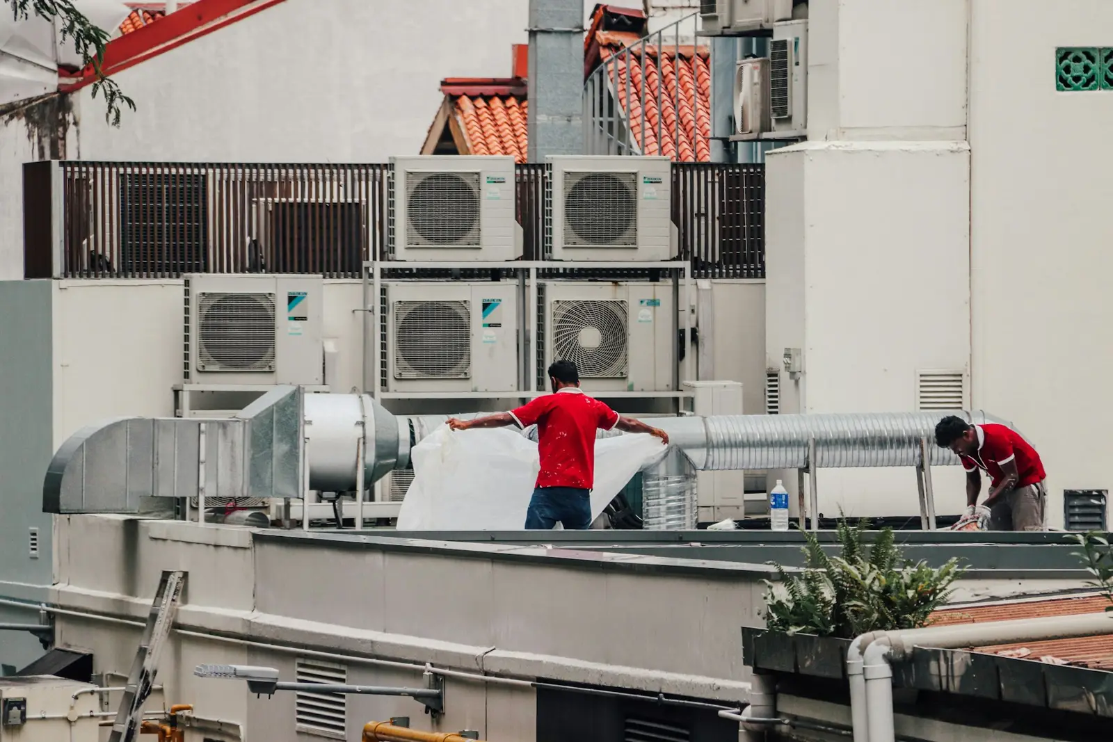 Técnicos trabajando entre unidades de climatización en una cubierta